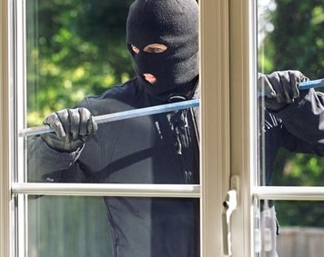 Person breaking into a house with a crowbar.